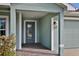 Charming covered front porch area with decorative columns and wood-look tile flooring at 470 Sunset N Rd, Rotonda West, FL 33947