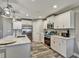 Well-lit kitchen with stainless steel appliances, white cabinets, a marble countertop, and wood-look tile flooring at 470 Sunset N Rd, Rotonda West, FL 33947