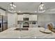 Kitchen featuring white cabinets, stainless steel appliances, a marble countertop island, and pendant lighting at 470 Sunset N Rd, Rotonda West, FL 33947