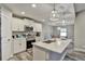 Bright kitchen with white cabinetry, a marble island, stainless steel appliances, and stylish pendant lights at 470 Sunset N Rd, Rotonda West, FL 33947