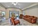 Bright living room featuring wood-look tile flooring, a ceiling fan, and access to a large backyard at 470 Sunset N Rd, Rotonda West, FL 33947