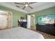 Spacious bedroom features a large TV, ceiling fan, and en suite bathroom at 4710 69Th E Ct, Palmetto, FL 34221