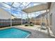 Relaxing screened-in pool area featuring lounge chairs, egg chair, and lush landscaping at 4710 69Th E Ct, Palmetto, FL 34221