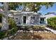 Charming home featuring beautiful landscaping, a cozy front porch, and a serene tree providing ample shade at 4925 16Th N Ave, St Petersburg, FL 33710