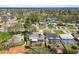 An aerial shot of a neighborhood with pools, mature trees, and water views, with a city skyline in the distance at 5050 Venetian Ne Blvd, St Petersburg, FL 33703