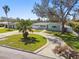 Lovely single-story home features a circular driveway, a palm tree, and a beautifully landscaped yard at 5050 Venetian Ne Blvd, St Petersburg, FL 33703