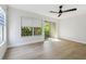 Bright bedroom with a ceiling fan, wood floors, a window, and sliding glass doors opening to a balcony at 520 Wheaton Trent Pl, Tampa, FL 33619