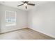 Simple bedroom with a ceiling fan, light wood floors, and a window with a shade at 520 Wheaton Trent Pl, Tampa, FL 33619