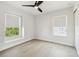 Bright bedroom features a ceiling fan, hardwood floors and natural light from two windows at 520 Wheaton Trent Pl, Tampa, FL 33619