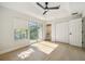 This bedroom features a balcony, wood floors, ceiling fan and closet with sliding doors at 520 Wheaton Trent Pl, Tampa, FL 33619