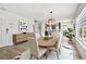 Dining room with stylish chairs, a wood table, and a view into a modern kitchen, perfect for entertaining guests at 520 Wheaton Trent Pl, Tampa, FL 33619