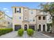Stylish three-story townhouse boasting a two-car garage, elegant arched entryways, and landscaped greenery at 520 Wheaton Trent Pl, Tampa, FL 33619