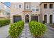 Charming townhouse front entrance featuring a wrought iron gate, stone pathway, and lush shrubbery at 520 Wheaton Trent Pl, Tampa, FL 33619