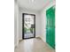Inviting hallway featuring neutral tile floors and a vibrant green door, creating a welcoming entrance at 520 Wheaton Trent Pl, Tampa, FL 33619