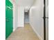 Bright hallway with a green door, leading to the staircase with wood-look tile flooring and fresh, white walls at 520 Wheaton Trent Pl, Tampa, FL 33619