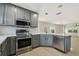 Modern kitchen with stainless steel appliances, light countertops, and gray cabinetry, offering a sleek design at 520 Wheaton Trent Pl, Tampa, FL 33619