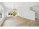 Bright and airy living room with wood floors, a ceiling fan, large windows, and a sliding door to a balcony at 520 Wheaton Trent Pl, Tampa, FL 33619