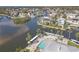 Waterfront property featuring a pool, boat dock, and lush landscaping with palm trees at 5722 Biscayne Ct # 308, New Port Richey, FL 34652