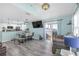 Spacious living area with wood floors, television, and sliding glass doors leading to a balcony at 5722 Biscayne Ct # 308, New Port Richey, FL 34652