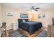 Cozy bedroom featuring a ceiling fan, wood-look flooring, and blue accents at 6415 River Ridge Rd, New Port Richey, FL 34653