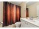 Bathroom with a neutral vanity, decorative shower curtain, and a toilet at 7224 E Bank Dr # 206, Tampa, FL 33617