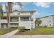 Two-story condo with blue doors and a well-manicured lawn surrounded by mature trees and ample greenery at 7224 E Bank Dr # 206, Tampa, FL 33617