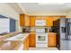 Well-lit kitchen boasts stainless steel appliances and plentiful wooden cabinets for storage at 7224 E Bank Dr # 206, Tampa, FL 33617