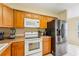 Modern kitchen with stainless steel refrigerator, white appliances, and light wood cabinetry at 7224 E Bank Dr # 206, Tampa, FL 33617