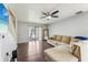 Bright living room features a ceiling fan, dark wood floors, a sliding glass door and cozy sofa at 7224 E Bank Dr # 206, Tampa, FL 33617