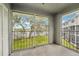 Screened porch with view of lake, featuring black metal railings, concrete floor, and white storage closet at 7224 E Bank Dr # 206, Tampa, FL 33617