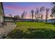 Expansive backyard with a paver patio and lush lawn overlooking a serene waterfront setting at 7730 N Mobley Rd, Odessa, FL 33556