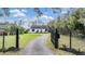 Charming white home featuring a gated entrance and well-maintained landscaping at 7730 N Mobley Rd, Odessa, FL 33556
