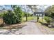 Gated entrance to a charming home with lush landscaping and mature trees at 7730 N Mobley Rd, Odessa, FL 33556