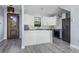 Modern kitchen featuring white cabinets, grey appliances, marble backsplash, and waterfall island with sink at 7730 N Mobley Rd, Odessa, FL 33556