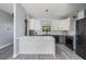 Bright kitchen with a center island, stainless steel appliances, and white and gray cabinetry at 7730 N Mobley Rd, Odessa, FL 33556
