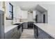 Contemporary kitchen boasts stainless steel appliances, a center island, and stylish two-tone cabinetry at 7730 N Mobley Rd, Odessa, FL 33556