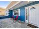 Inviting front porch featuring two chairs, a small table, and a welcoming white door with a half-moon window at 8248 Goodrich St, Spring Hill, FL 34606