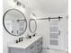 Modern bathroom features a double sink vanity, round mirrors, matte black fixtures, and a tiled shower at 8432 Merrimoor Blvd, Seminole, FL 33777