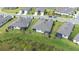 A high-angle aerial view shows modern homes with screened patios in a green, lakeside community at 8435 Ocean Tides Cv, Parrish, FL 34219