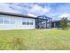 View of backyard featuring lawn and screened lanai, great for outdoor living at 8435 Ocean Tides Cv, Parrish, FL 34219