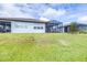 Expansive backyard featuring lush green grass, a screened-in patio, and a tranquil setting at 8435 Ocean Tides Cv, Parrish, FL 34219