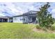 Spacious backyard with lush grass, mature landscaping, and a screened-in patio for outdoor enjoyment at 8435 Ocean Tides Cv, Parrish, FL 34219