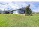 Well-maintained backyard with lush green grass, a screened lanai, and a view of neighboring homes at 8435 Ocean Tides Cv, Parrish, FL 34219