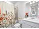 Cozy bathroom featuring a shower with floral shower curtain, tile backsplash, toilet, and modern sink at 8435 Ocean Tides Cv, Parrish, FL 34219