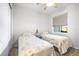 Cozy bedroom with two twin beds, carpet flooring, and a window providing natural light at 8435 Ocean Tides Cv, Parrish, FL 34219
