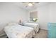 Bright bedroom with two twin beds, carpet flooring, side-table, ceiling fan and a window providing natural light at 8435 Ocean Tides Cv, Parrish, FL 34219