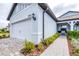 Exterior side view of home featuring an attached two-car garage, lovely landscaping, and paver walkway at 8435 Ocean Tides Cv, Parrish, FL 34219