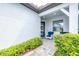 Inviting front porch with blue chairs, decorative wreath on door, and stone walkway at 8435 Ocean Tides Cv, Parrish, FL 34219