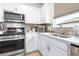 Close-up of kitchen featuring stainless steel oven, cooktop, and stylish white cabinets and backsplash at 8435 Ocean Tides Cv, Parrish, FL 34219