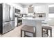 Modern kitchen with stainless steel appliances, island with seating, and stylish white cabinetry at 8435 Ocean Tides Cv, Parrish, FL 34219